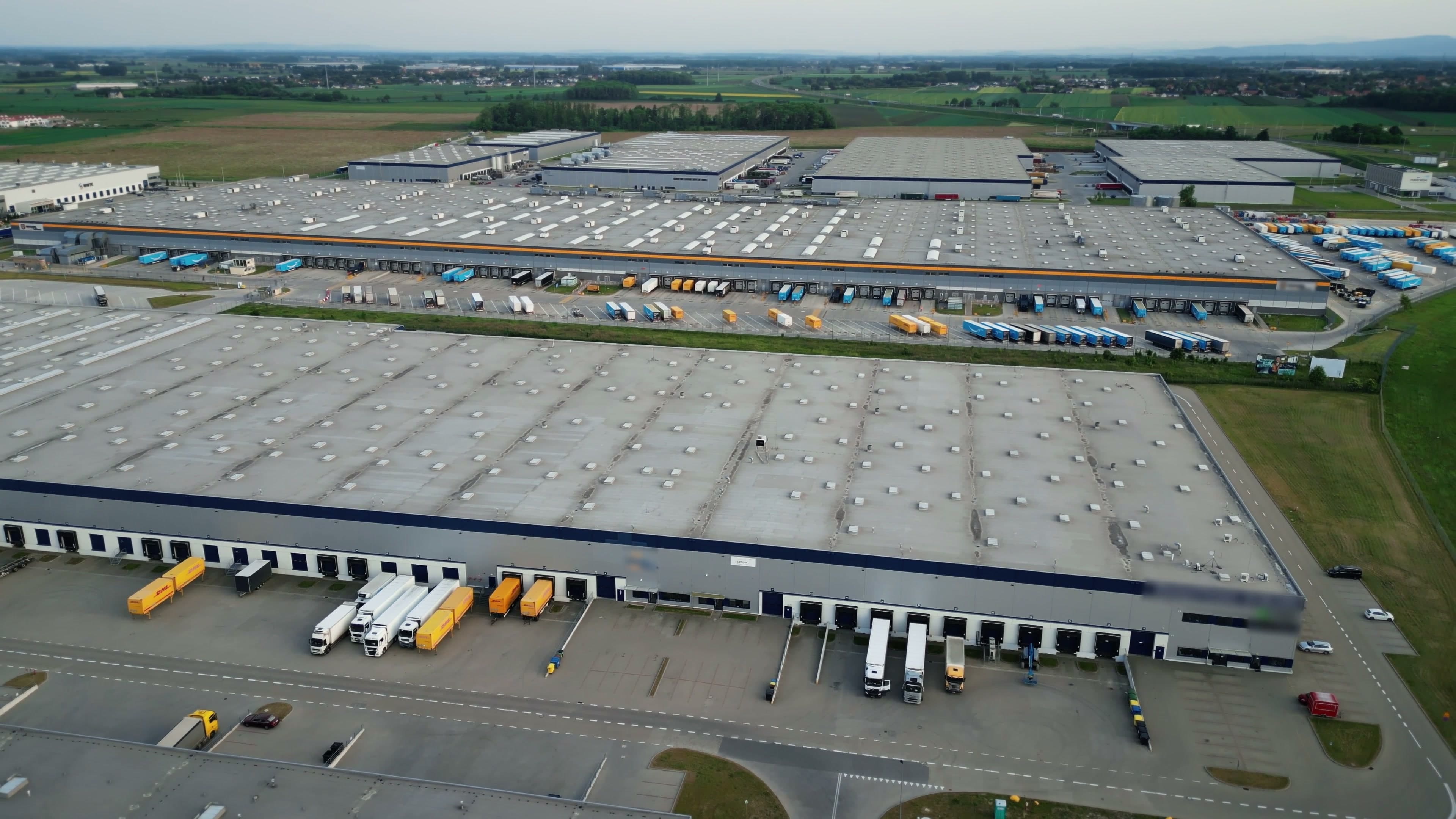 Aerial view of massive distribution center campus with dock doors and fleet
