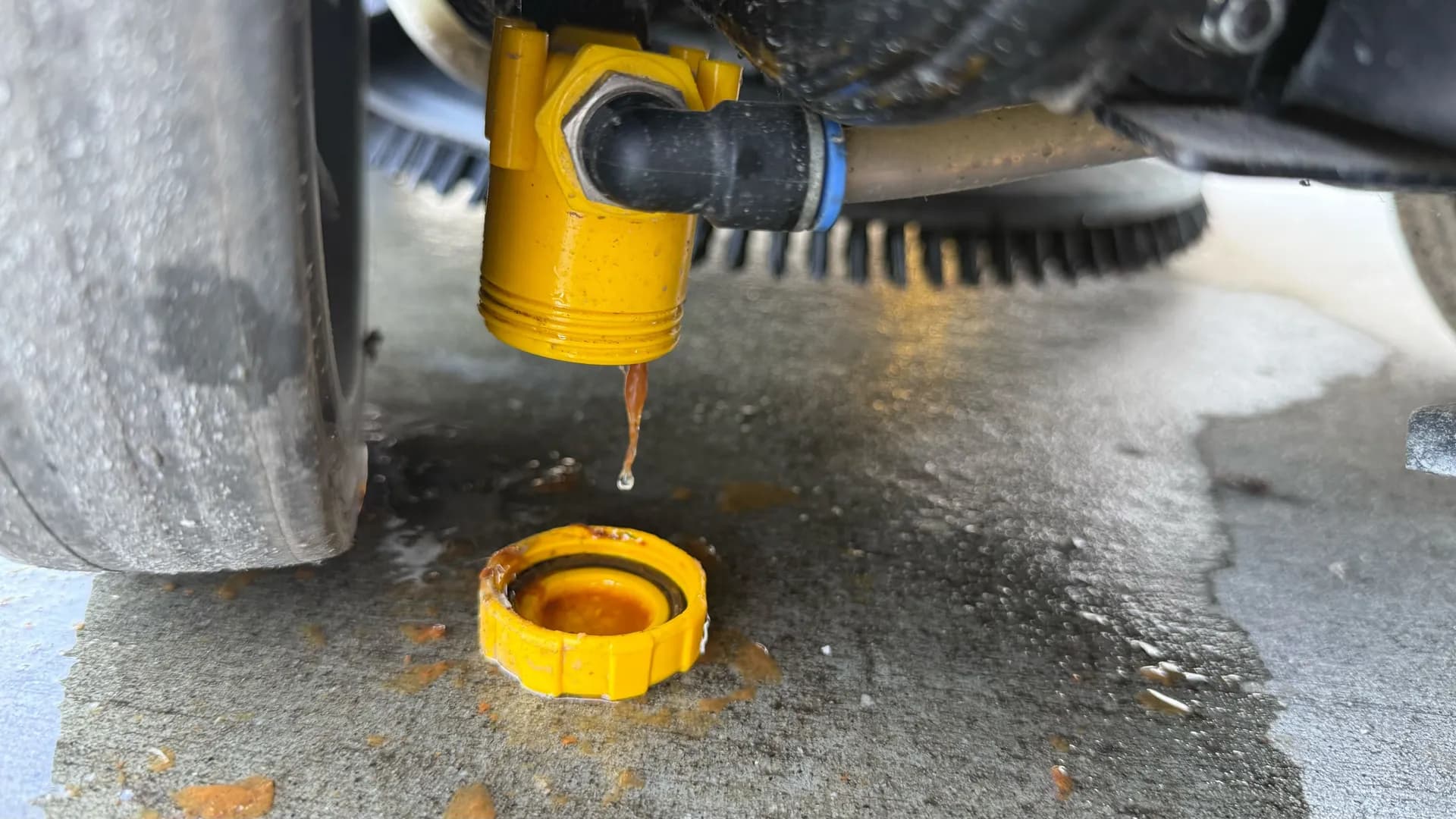 Technician diagnosing a solution valve on a commercial floor scrubber