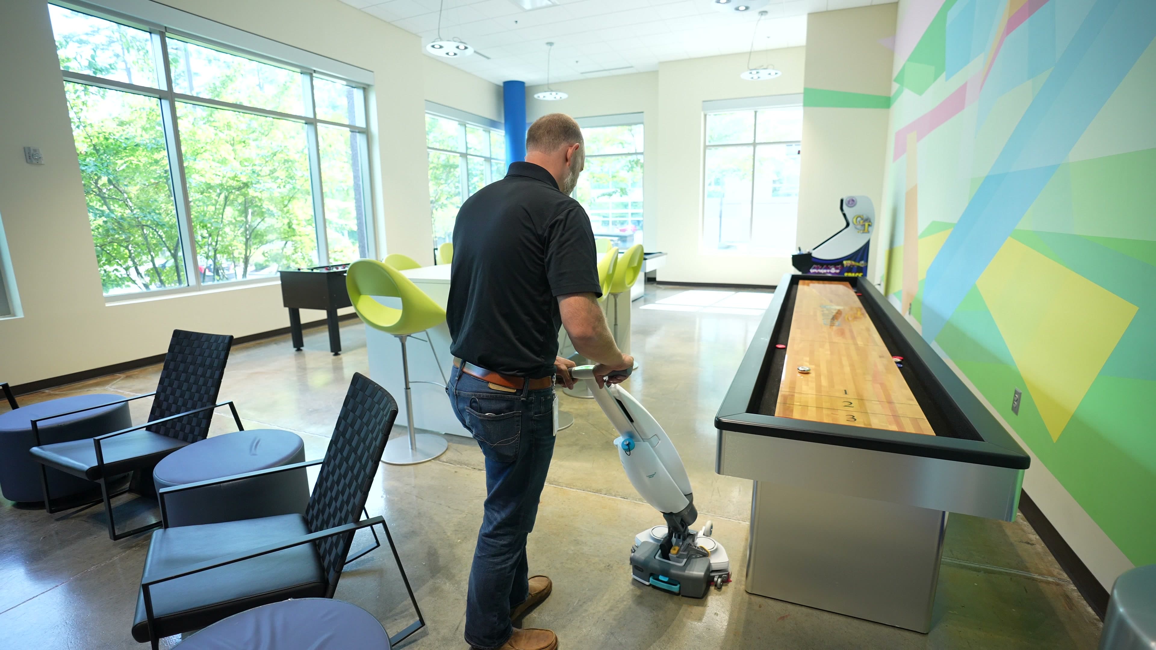MFS technician operating floor buffer in a large studio space