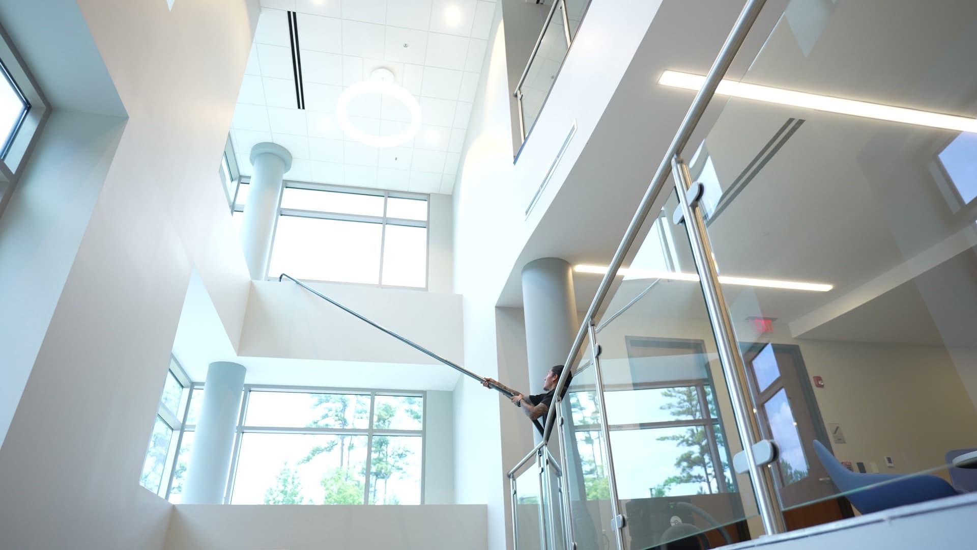 High-reach cleaning equipment in use inside a cinematic corporate atrium