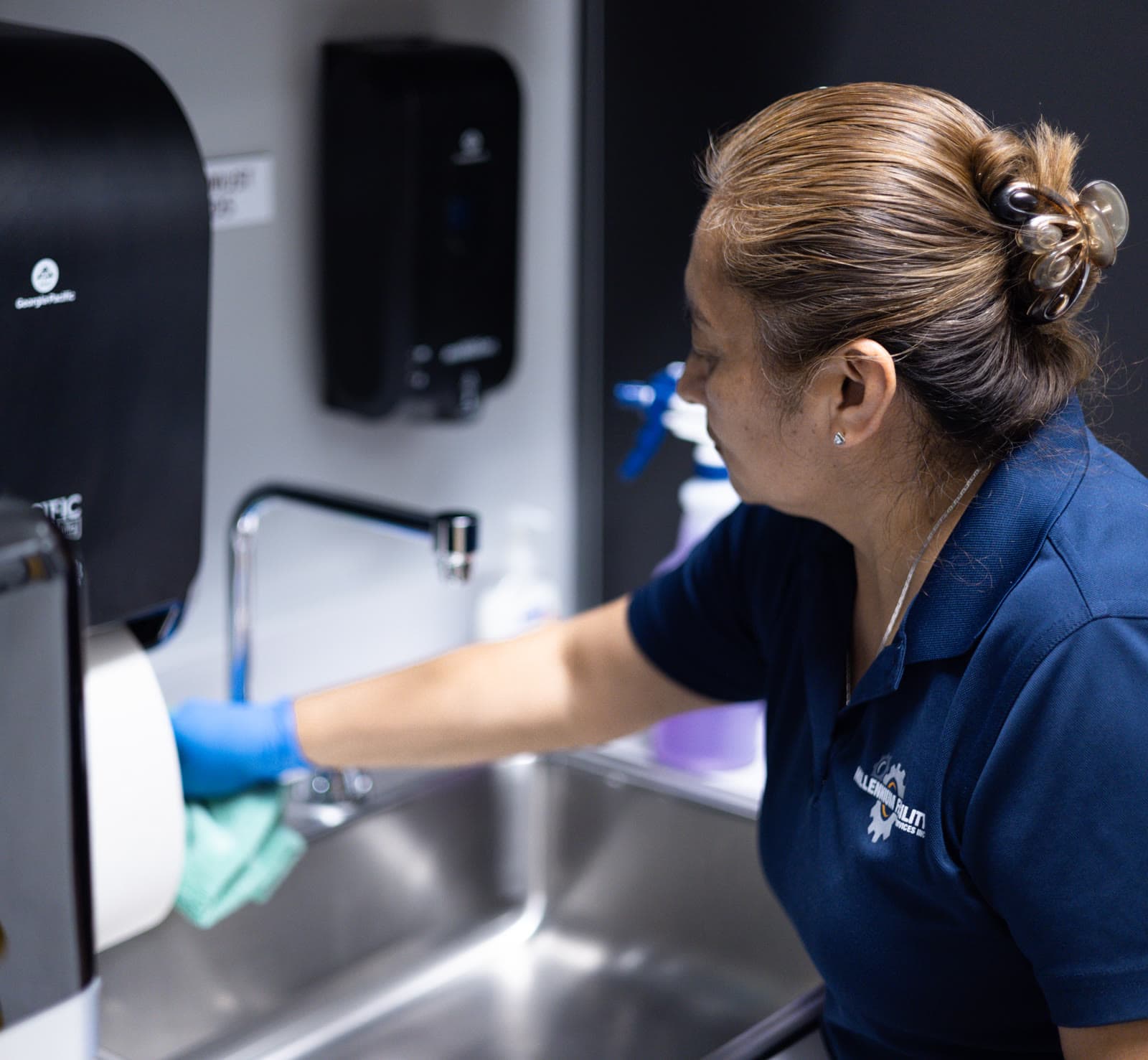 MFS technician cleaning sink in manufacturing environment